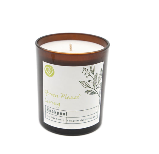 A soy candle in amber jar on a white background