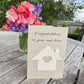 Moving house card with detachable seed paper house.