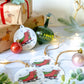 Festive plantable gift tags featuring red and green ice skates surrounded by snowflakes, displayed with Christmas ornaments and wrapped gifts.